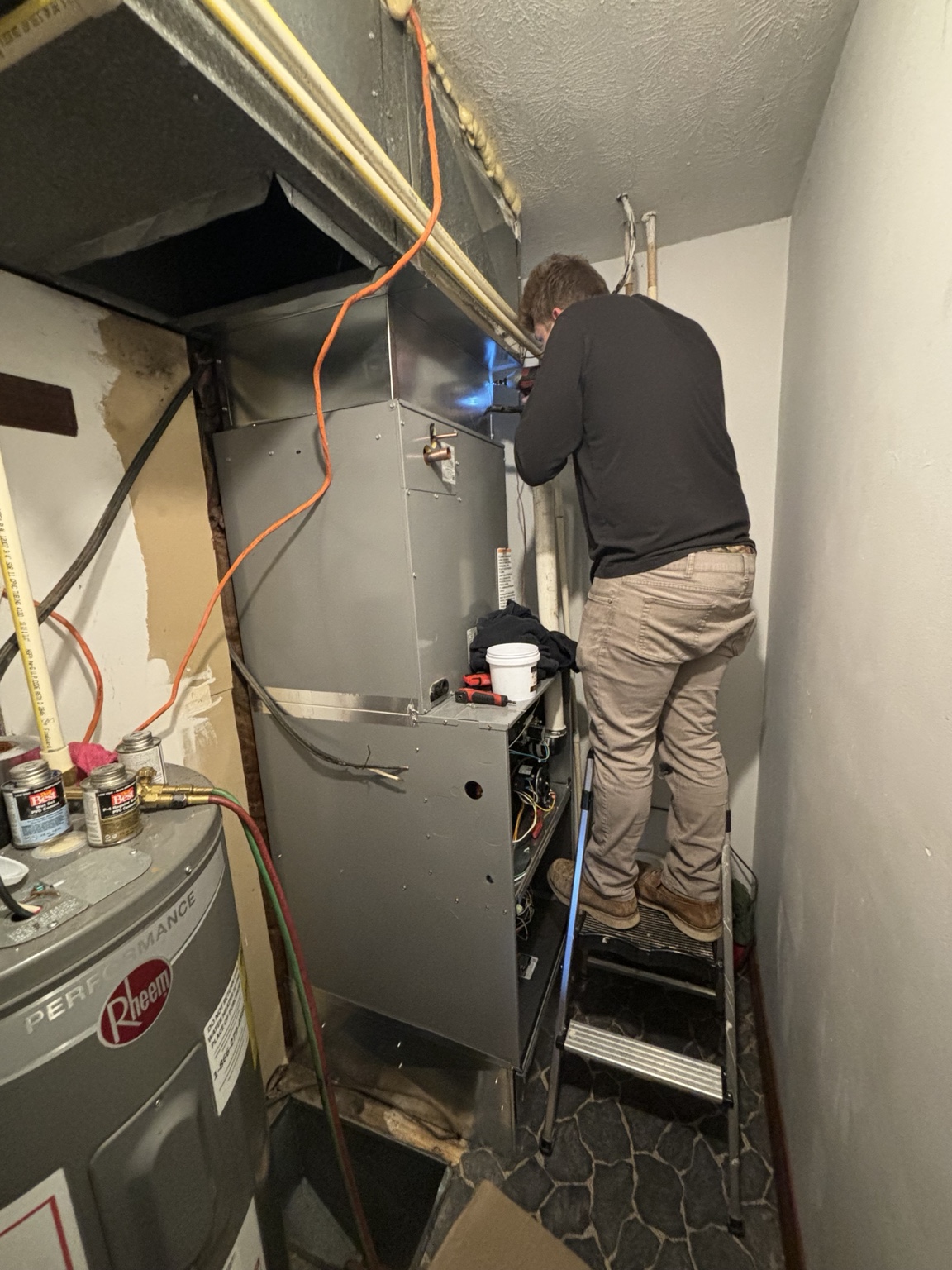 Technician servicing an indoor HVAC system